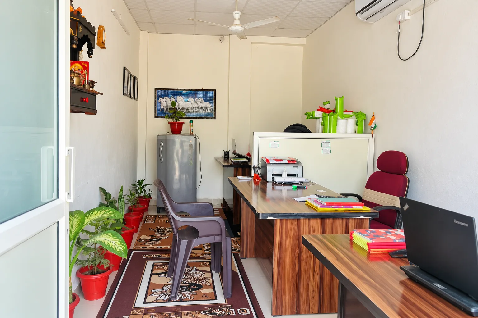 AI-recreated view of our office with woodgrain desks, visitor chairs and potted plants